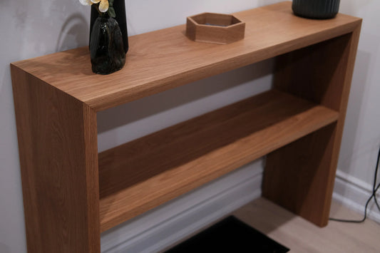 Handmade wooden console table with an open lower shelf and decorative objects on top