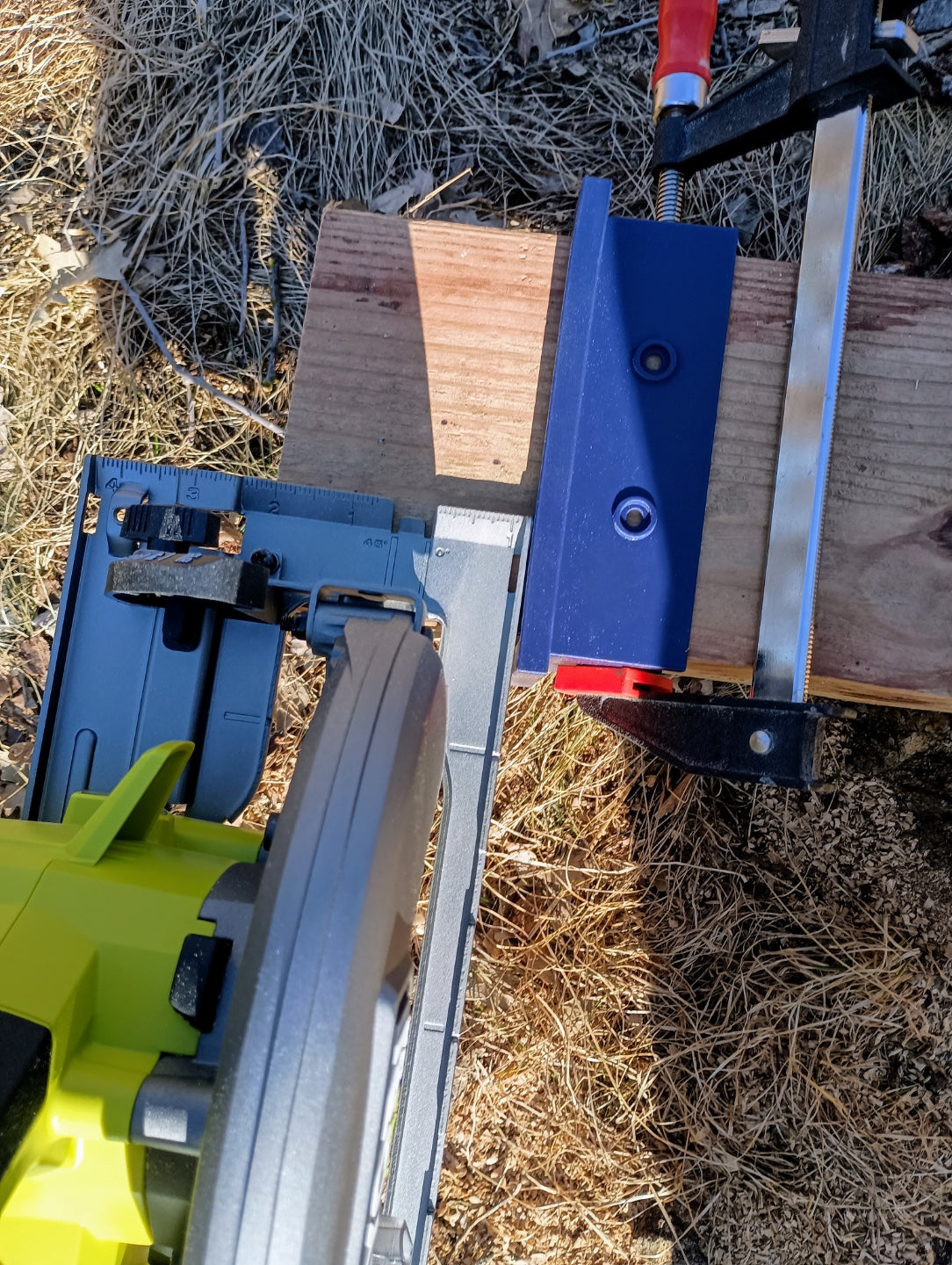 Close-up of circular saw beside a post cutting guide clamped to timber, showing the cutting alignment