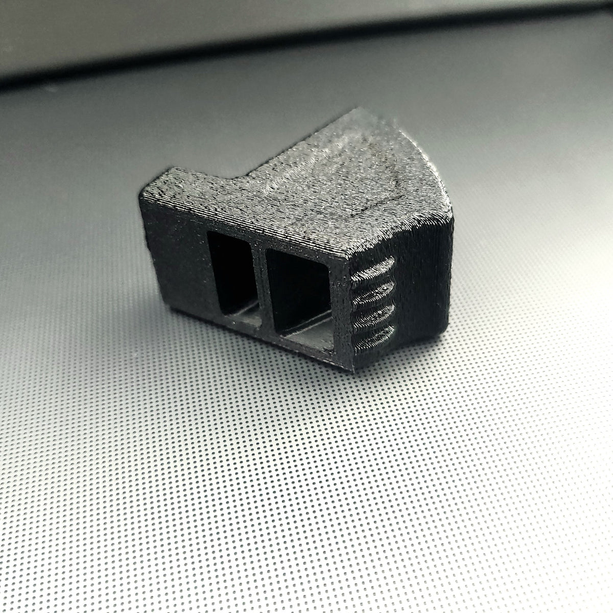 Close up of two vertical vent freshener clip receiving openings in black 3D printed Tesla vent adapter