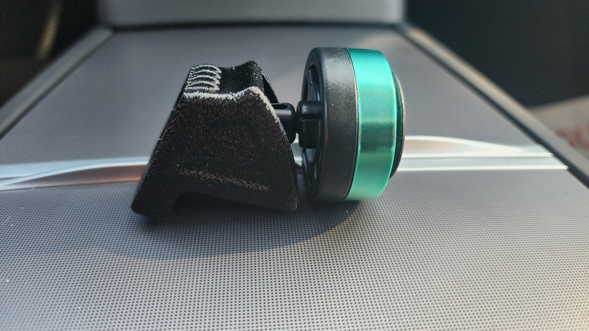 Side profile showing separately available air freshener clipped onto Tesla dashboard vent adapter