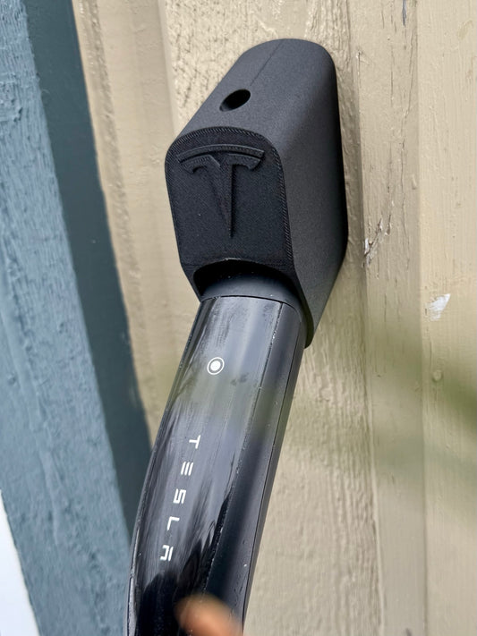 Black secure-fit Tesla NACS charging plug dock with charging handle stored on a wooden post