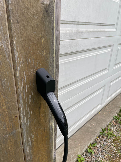 Secure-fit Tesla charging handle holder installed on a timber post alongside a garage door