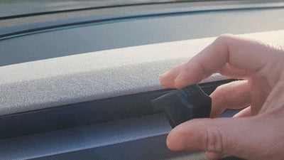 Demonstration hand placing small Tesla Highland Juniper adapter into front horizontal dashboard air vent