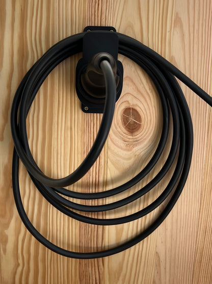 Type 2 EV charging cable organized on black 3D printed wall mount installed on wood wall