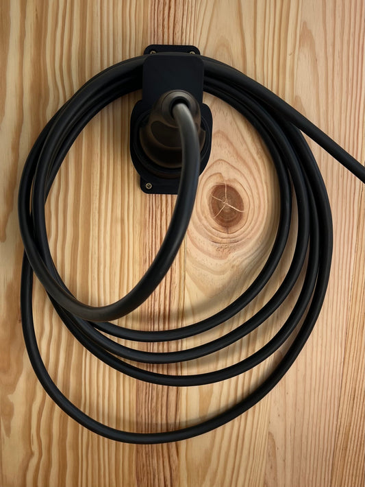 Type 2 EV charging cable organized on black 3D printed wall mount installed on wood wall