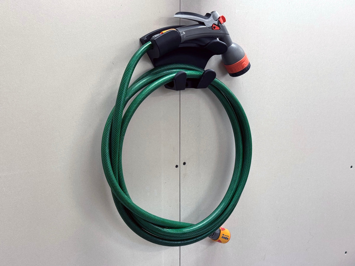 Alternative garden-hose use of the universal wall mount with coiled green hose and nozzle
